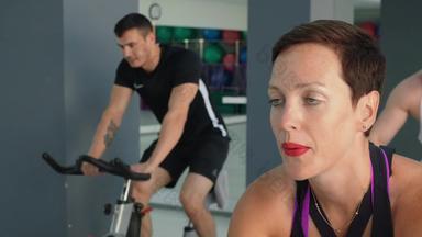 微笑女人培训静态自行车骑自行车类肖像适合女人自行车培训健身房集团运动员人练习自行车培训健康的俱乐部